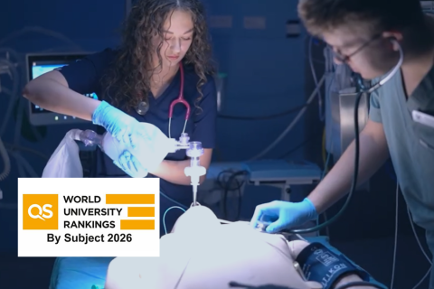 Two healthcare professionals wearing gloves administer intravenous treatment to a patient on a hospital bed, with medical monitors in the background and the “QS World University Rankings by Subject 2026” logo displayed in the corner.