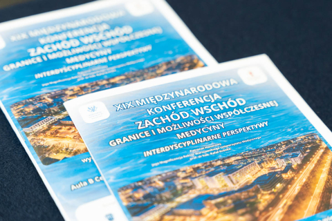 Conference leaflets arranged on a table, featuring the title “19th International Conference East–West. Boundaries and opportunities of contemporary medicine” and a city panorama image.