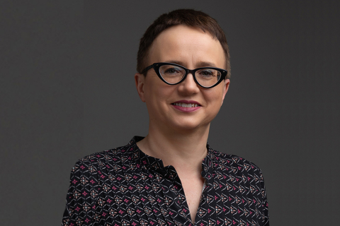 A woman, prof. Dagmara Mirowska-Guzel, wearing glasses and a patterned shirt posing for a portrait.