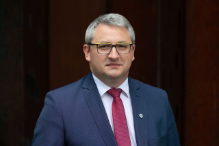 Elegancko ubrany mężczyzna w okularach, Patryk Rzońca.